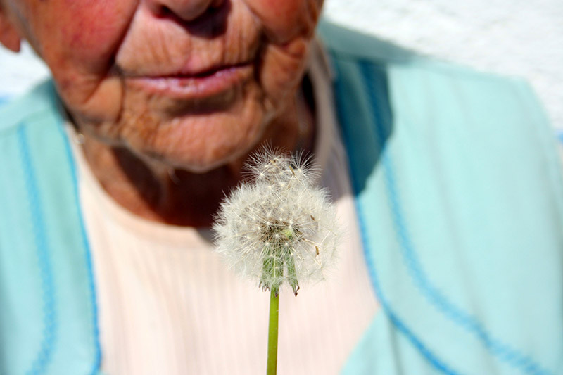Mujer con deterioro cognitivo bufando una flor