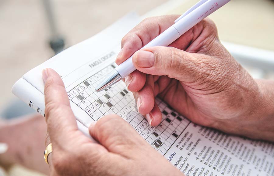 Vista d'una persona gran completant un mots encreuats.