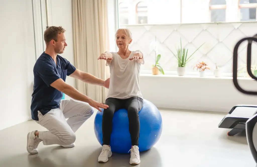Anciana sentada encima de una pelota de pilates