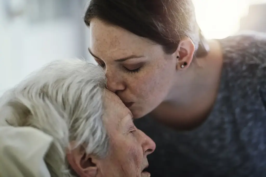Mujer dando un beso a una anciana